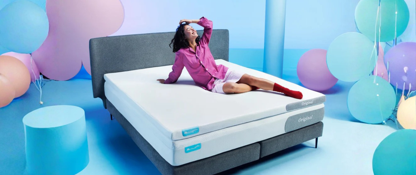 Vrouw zit op bed in showroom
